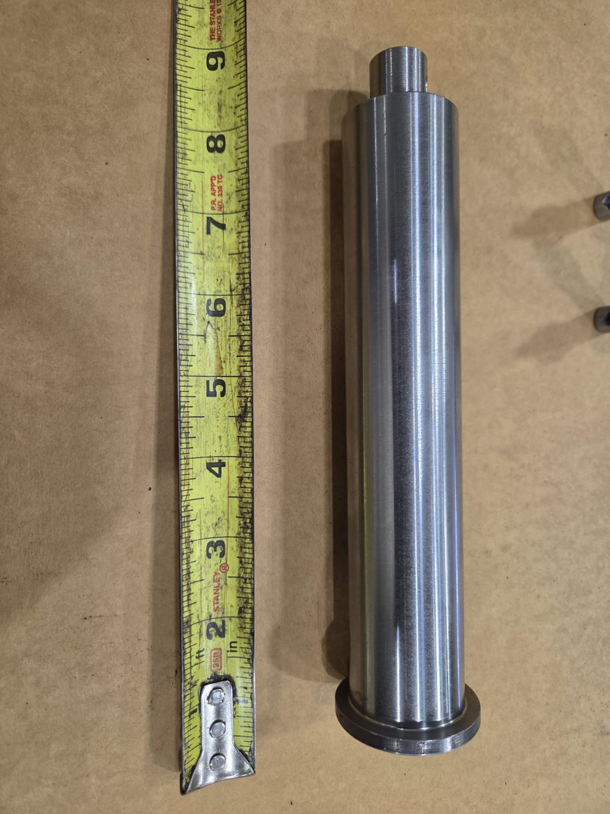 Precision turned shaft shown with tape measure for scale